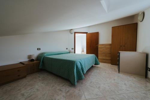 a bedroom with a green bed and wooden cabinets at Sguardo sul mare in Petacciato