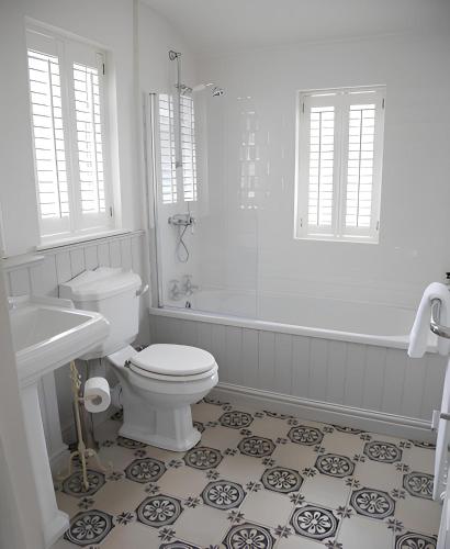 a white bathroom with a toilet and a shower at Maison 5 in Harrogate