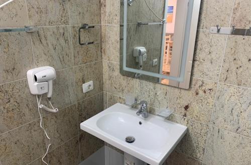 a bathroom with a sink and a mirror at Fishta Quality Apartments Q5 31 in Velipojë