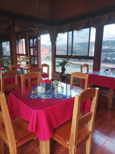 a dining room with a pink table and chairs at Cabañas Mountain River Lake Inn in Nueva California