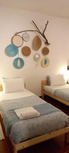 um quarto com duas camas e um relógio na parede em Murta's Home em Cadaval