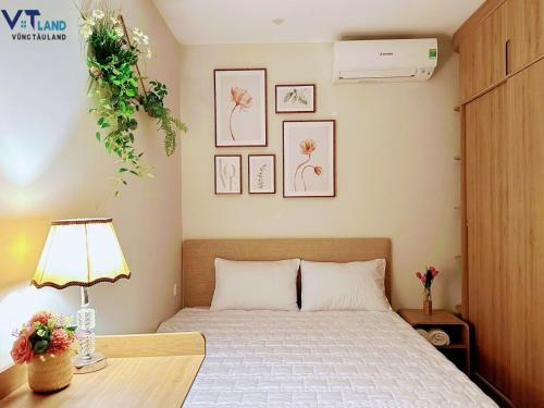 a bedroom with a bed and a desk with a lamp at The Sóng Hotel & Apartment Vũng Tàu in Vung Tau