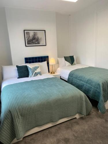 a bedroom with two beds and a lamp at GUEST ROOMS in CAMDEN TOWN in London