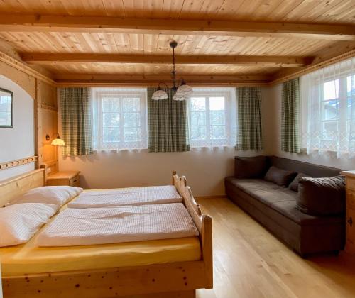 ein Schlafzimmer mit einem großen Bett und einem Sofa in der Unterkunft Stoanahof in Virgen
