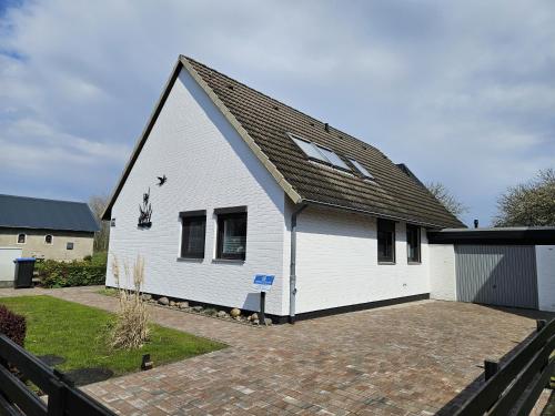 a white house with a black roof at Haus Schwalbennest in Dahme