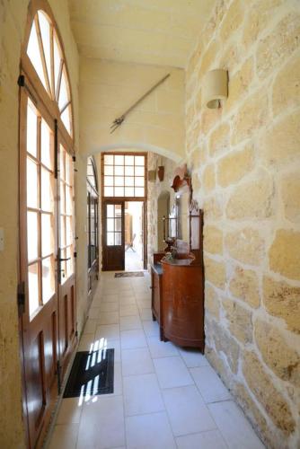a hallway of a house with a stone wall at 6 Bedroom Farmhouse with Large Private Pool in Żebbuġ