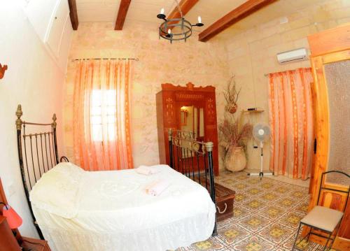 a bedroom with a bed in a room at 6 Bedroom Farmhouse with Large Private Pool in Żebbuġ