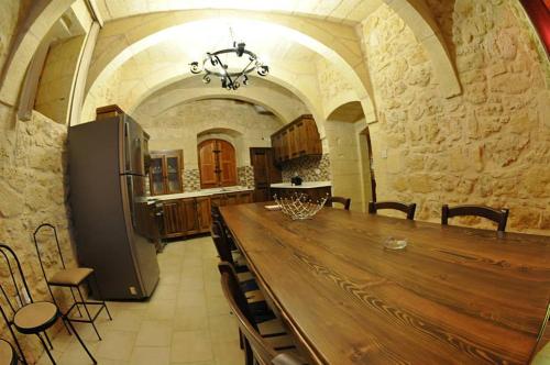 a large kitchen with a large wooden table and chairs at 6 Bedroom Farmhouse with Large Private Pool in Żebbuġ