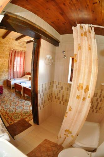 a bathroom with a tub and a shower with a toilet at 6 Bedroom Farmhouse with Large Private Pool in Żebbuġ