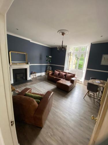 a living room with two couches and a fireplace at The Cafe Apartment in Great Malvern
