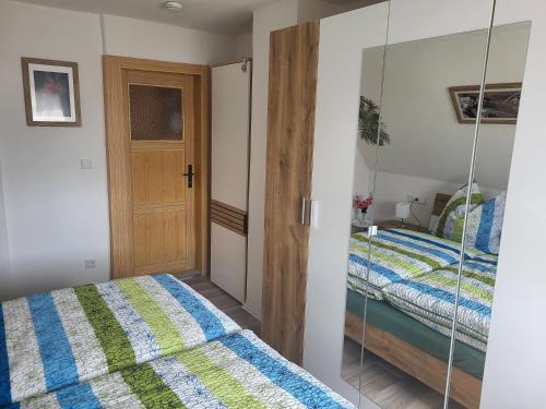 - une chambre avec 2 lits et une porte en verre dans l'établissement Ferienhaus Keppler im Erzgebirge, à Sayda