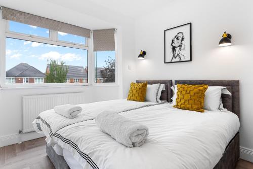 2 Betten in einem weißen Zimmer mit Fenster in der Unterkunft 3 Bedroom House close to Dartford Station in Dartford