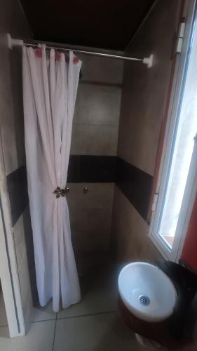La salle de bains est pourvue d'un rideau de douche blanc et d'un lavabo. dans l'établissement LOFT Huayna picchu, à La Falda