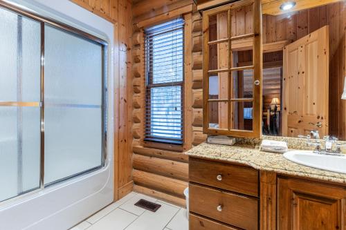 ein Badezimmer mit einem Waschbecken und einem Fenster in der Unterkunft Fiddler lake Resort Chalet 86 Deer in Mille-Isles
