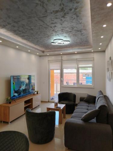a living room with a couch and a tv at Apartman Branković Pirot-Zapadni Kej 58 in Pirot
