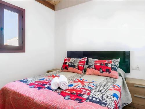 a bed with a red truck and pillows on it at Bungalow para familias y parejas in Cádiz