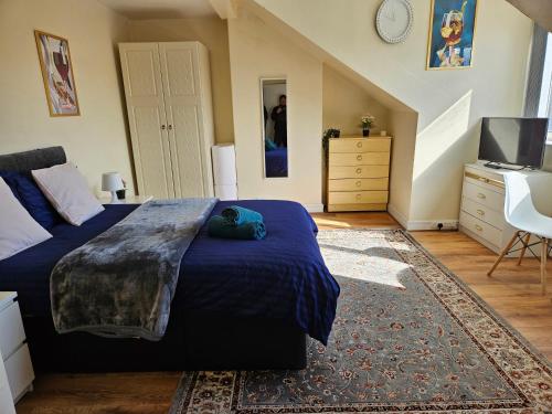 a bedroom with a large bed and a television at Homely double bed, TV, Wi-Fi and garden in Leeds