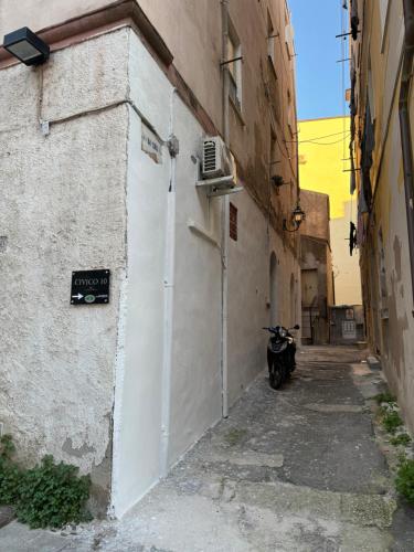 an alley with a motorcycle parked next to a building at Civico 10 II in Sassari