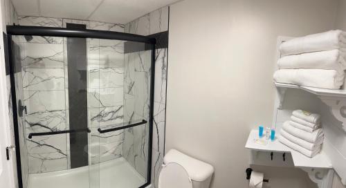 a bathroom with a shower and a toilet and towels at Green Harbor Hotel in Marshfield