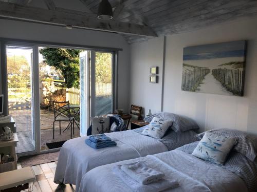 two beds in a bedroom with a balcony at Ger Tŷ, Reynoldston in Swansea