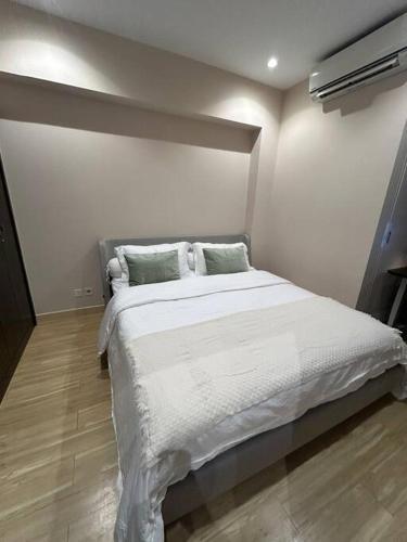 ein Schlafzimmer mit einem großen Bett mit weißen Laken und Kissen in der Unterkunft 1BR Branz BSD: PS5, King Size Bed, and 4K OLED TV in Tangerang
