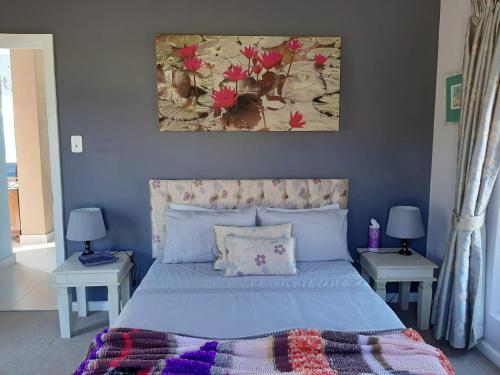 a blue bedroom with a bed with two tables at Katberg Mountain View House in Balfour