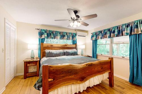 a bedroom with a wooden bed and a ceiling fan at Bradley Bear Hideaway in Maggie Valley