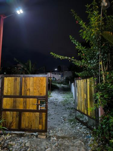 a wooden gate in a yard at night at Bayabas Lounge in Amadeo