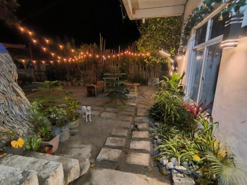 a patio with a table and lights and plants at Bayabas Lounge in Amadeo