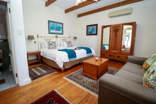 a living room with a bed and a couch at Altes Landhaus Country Lodge in Oudtshoorn