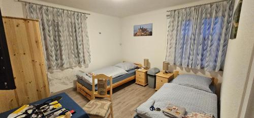a small room with two beds and two windows at Gasthaus Ochsen in Rottweil
