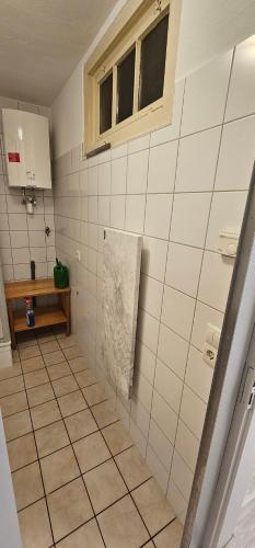 a bathroom with white tiled walls and a window at Gasthaus Ochsen in Rottweil