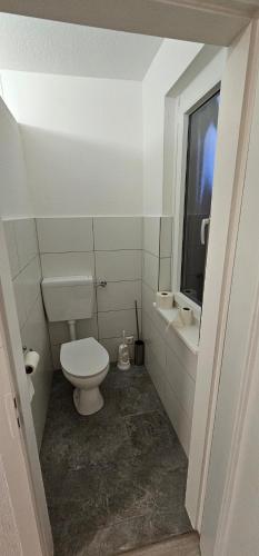 a white bathroom with a toilet and a window at Gasthaus Ochsen in Rottweil