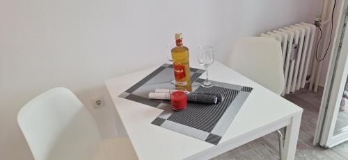a white table with a bottle of wine and a glass at Aurora with the view in Rijeka