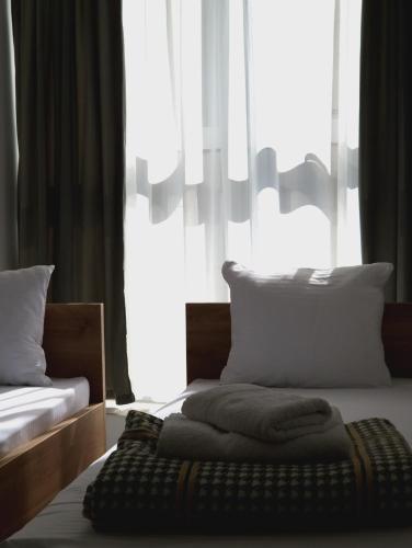 a bedroom with two beds and a large window at Apartmani Maksa in Stanovo