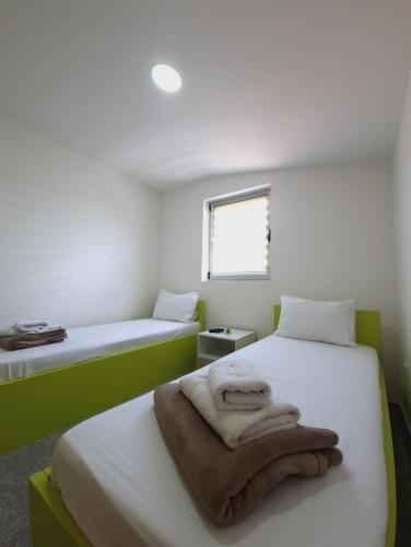 a bedroom with two beds with towels on them at Apartmani Maksa in Stanovo