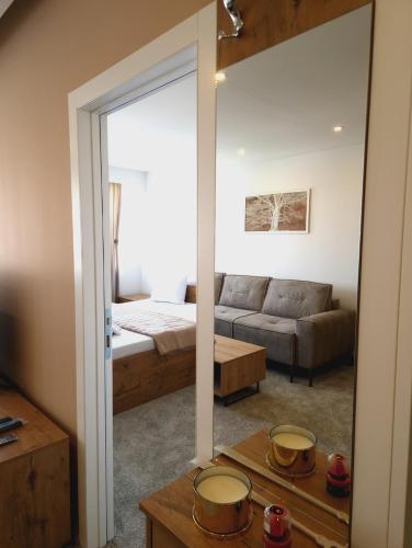 a living room with a bed and a mirror at Apartmani Maksa in Stanovo