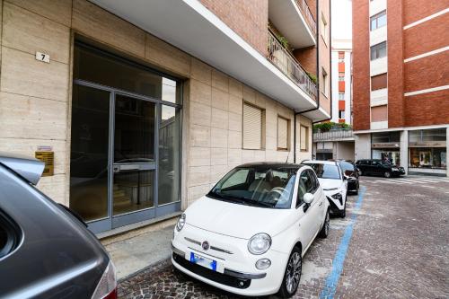 um pequeno carro branco estacionado ao lado de um edifício em Langhe Beauty Apartament Experience 2 "wine" em Alba