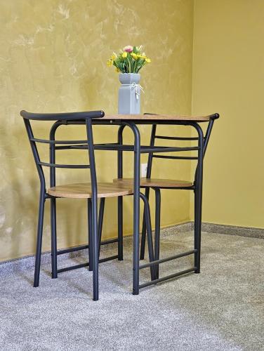 a table and a chair with a vase of flowers at Apartmani Maksa in Stanovo