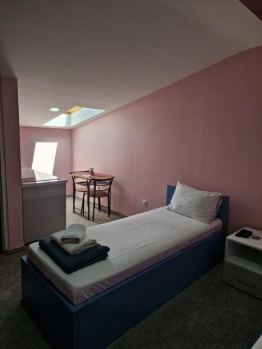 a bedroom with a bed and a table in a room at Apartmani Maksa in Stanovo