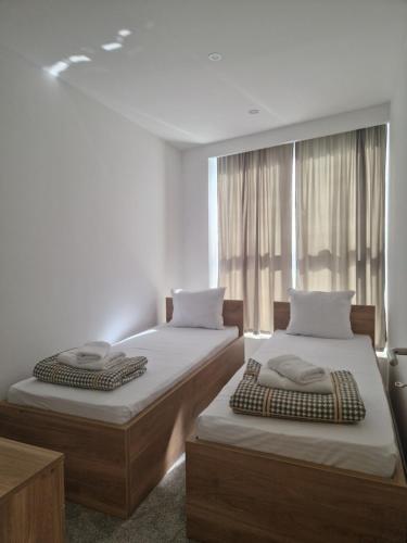 two beds in a room with a window at Apartmani Maksa in Stanovo