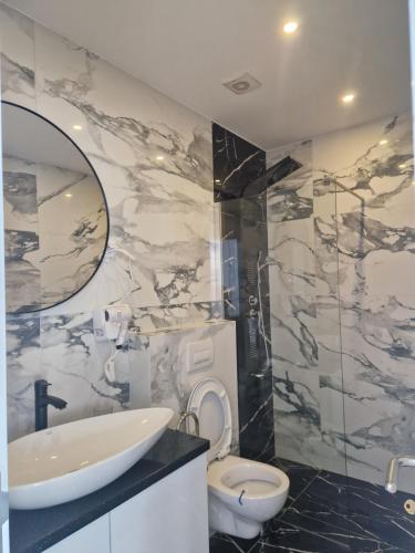 a bathroom with a sink and a toilet and a mirror at Apartmani Maksa in Stanovo