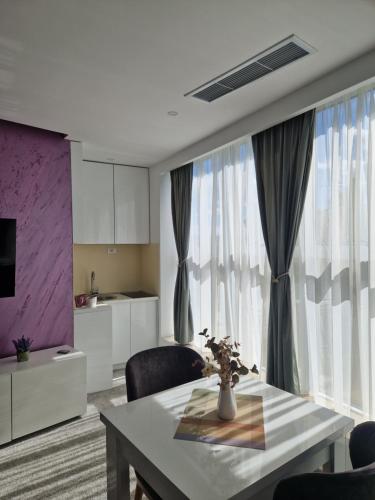 a living room with a table and a kitchen at Apartmani Maksa in Stanovo