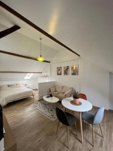 a living room with a couch and a table and chairs at Studio confortable et fonctionnel proche gare in Méru