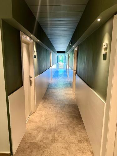 a hallway with a long corridor with green walls at Hotel Everest - Bar e Ristorante in Gabicce Mare