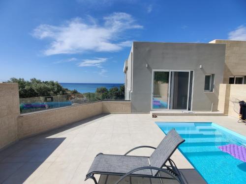 a villa with a swimming pool and a patio at Tesoro Del Mare in Pefki Rhodes