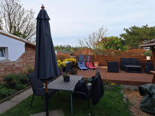 a patio with a table and an umbrella at Studio Edeltraud zentral in Wernigerode