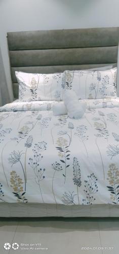 ein Bett mit einer weißen Bettdecke mit Blumen darauf in der Unterkunft Tambuli Resort Tower D in Lapu Lapu City