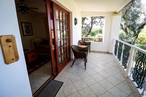 a room with a balcony with a table and chairs at Altes Landhaus Country Lodge in Oudtshoorn