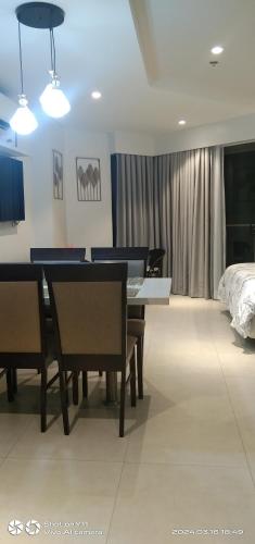 ein Esszimmer mit einem Tisch, Stühlen und einem Bett in der Unterkunft Tambuli Resort Tower D in Lapu Lapu City
